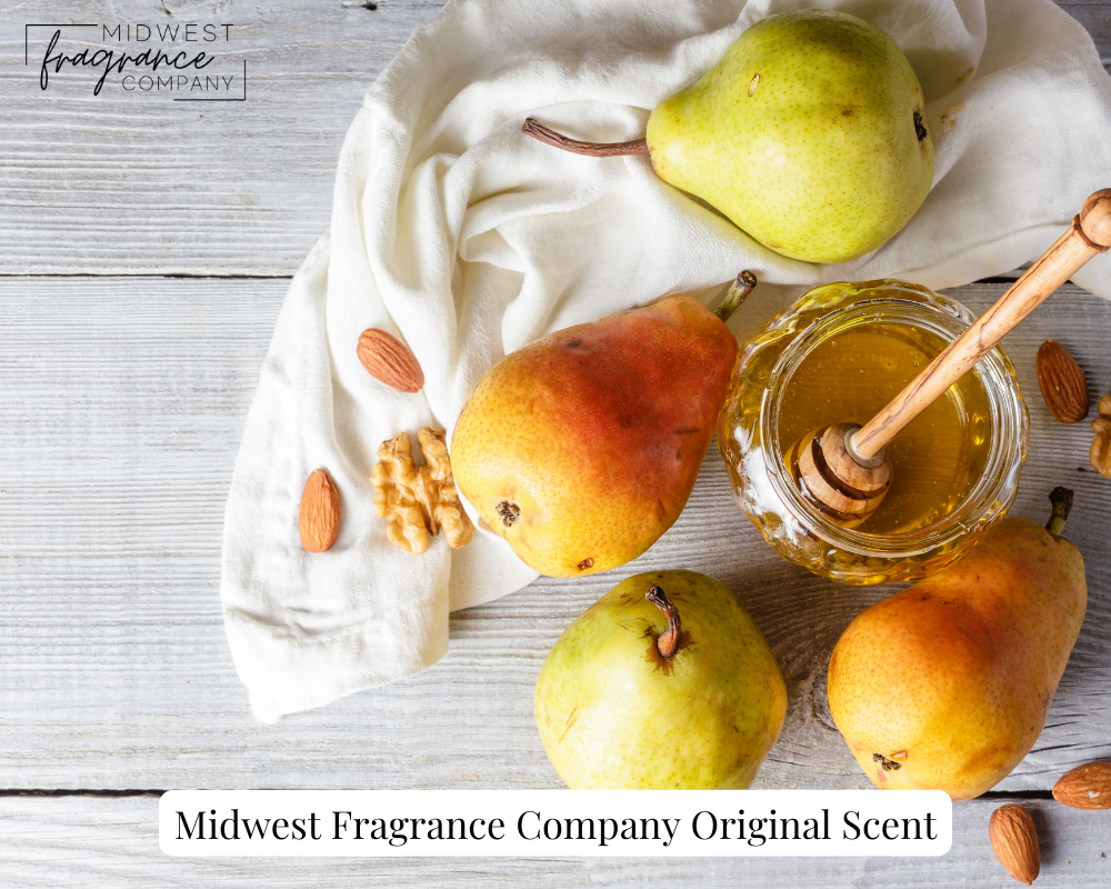 Four ripe pears, a jar of honey, and assorted nuts on a rustic white table depicting a fragrance called Honey Spiced Pear.