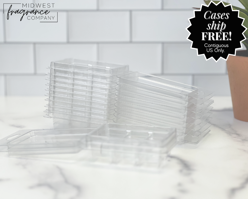 A stack of 6-cavity clear clamshell containers, used for making wax melts or tarts, on a white marble surface.